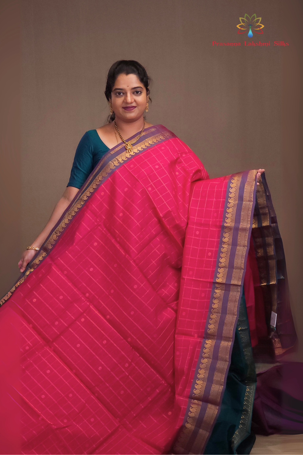 Woman wearing a pink saree with a brown background