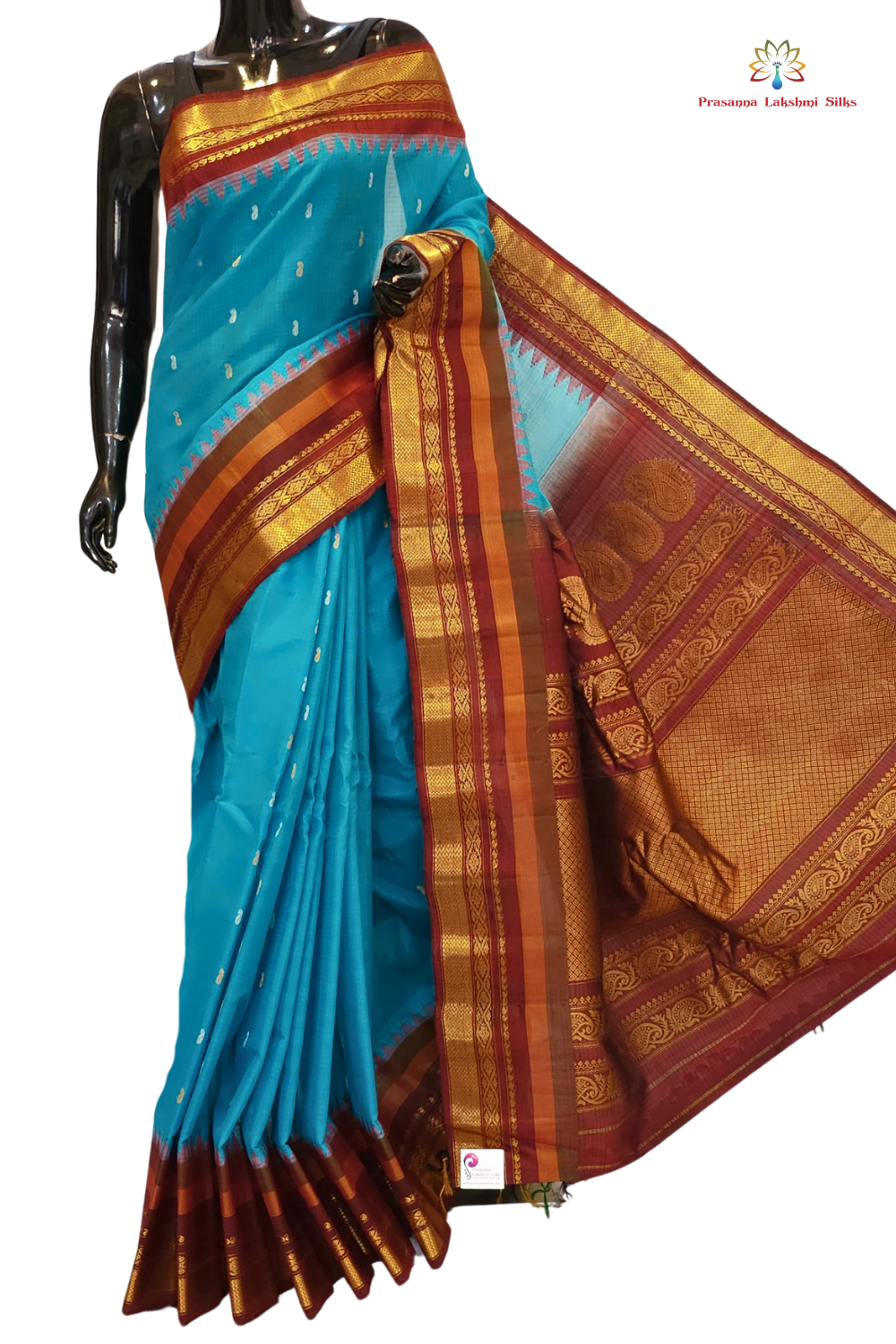 Handloom Gadwal silk cotton saree with all-over zari buttis and rich brocade pallu.
