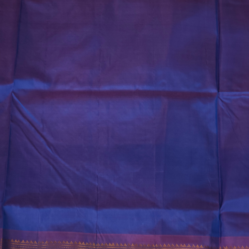 Copper sulphate blue and lilac Gadwal saree draped, showing brocade pallu and lilac blouse