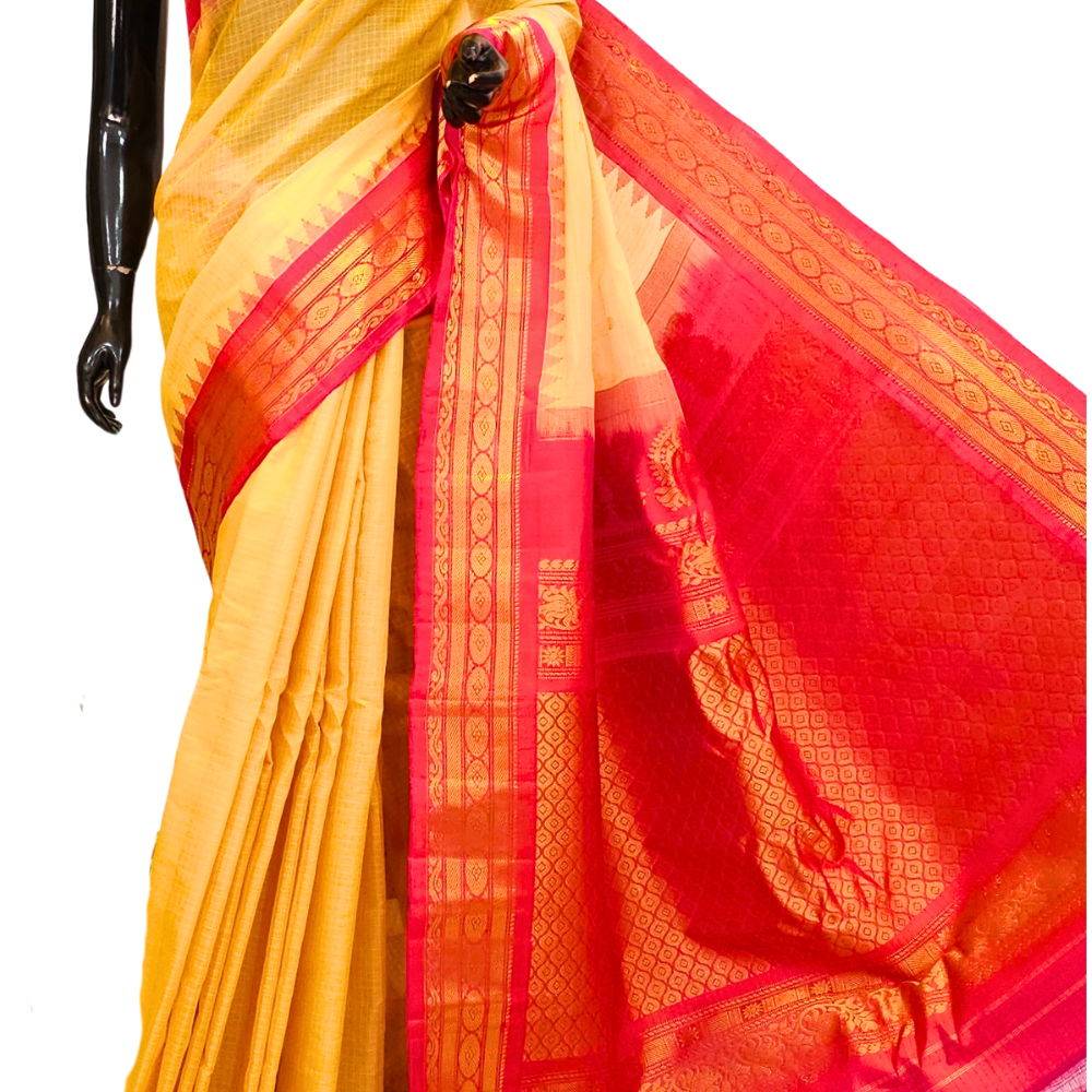 Handloom Gadwal silk cotton saree with all-over zari buttis and rich brocade pallu.
