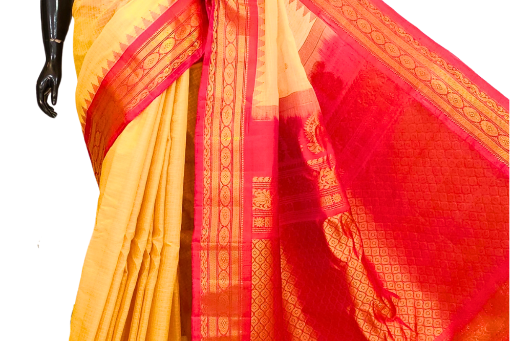 Handloom Gadwal silk cotton saree with all-over zari buttis and rich brocade pallu.
