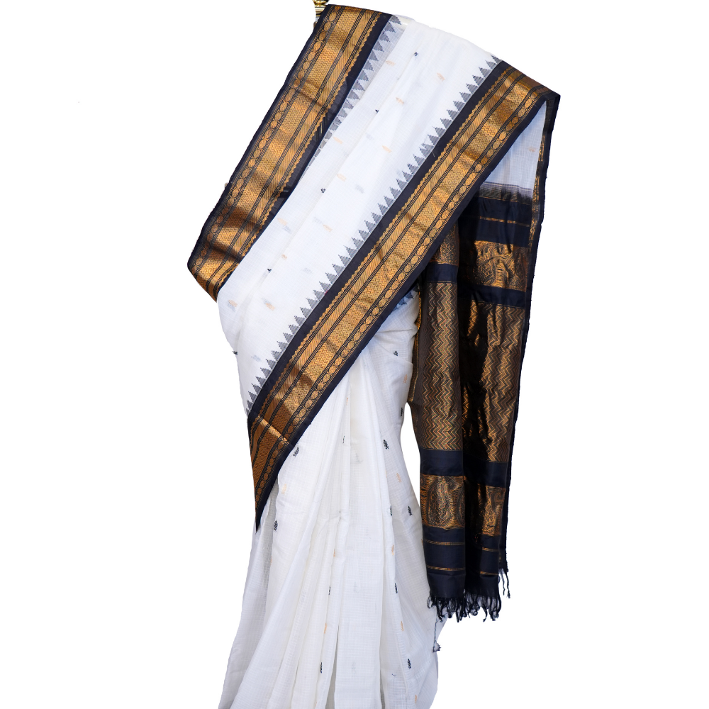 Handloom Gadwal silk cotton saree with all-over zari buttis and rich brocade pallu.
