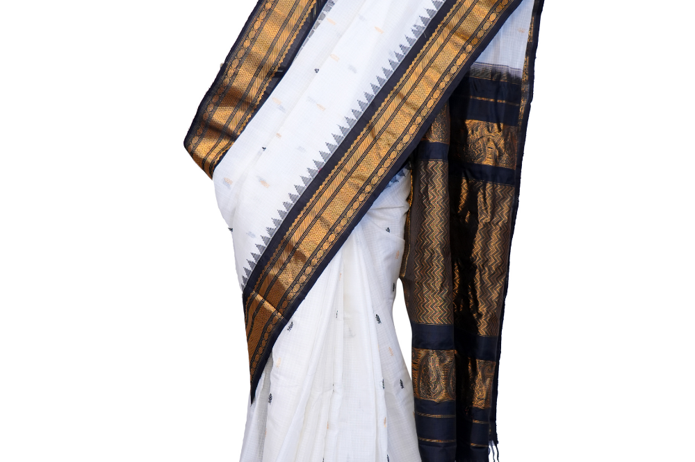 Handloom Gadwal silk cotton saree with all-over zari buttis and rich brocade pallu.
