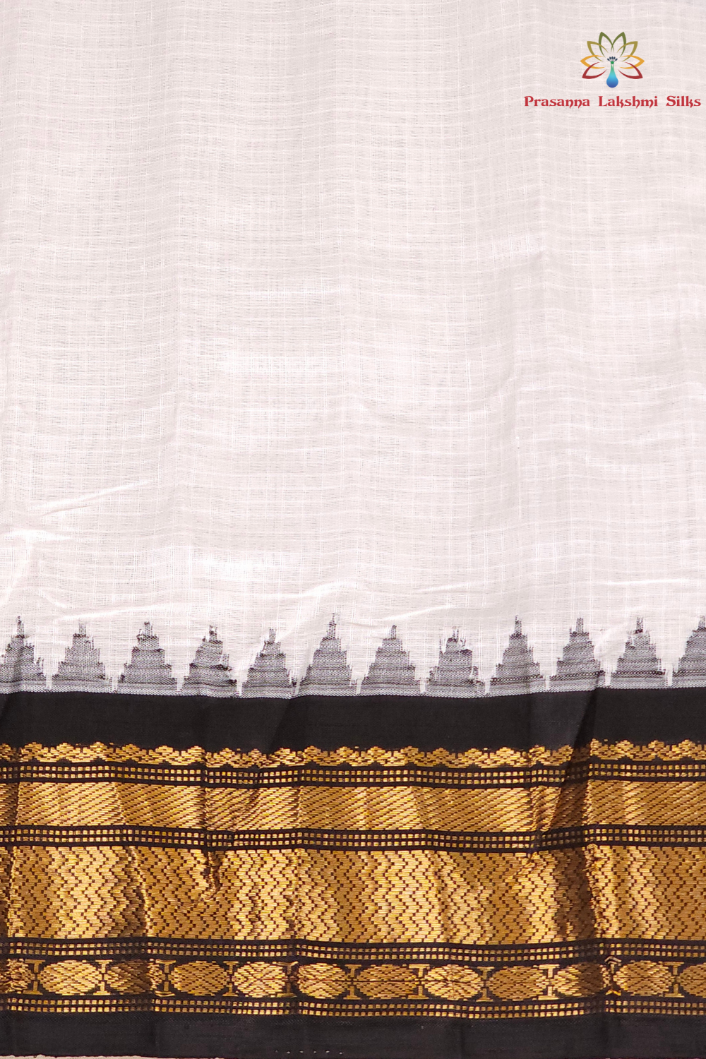 Half white and black handloom Gadwal saree draped, showing blouse piece and zari detailing