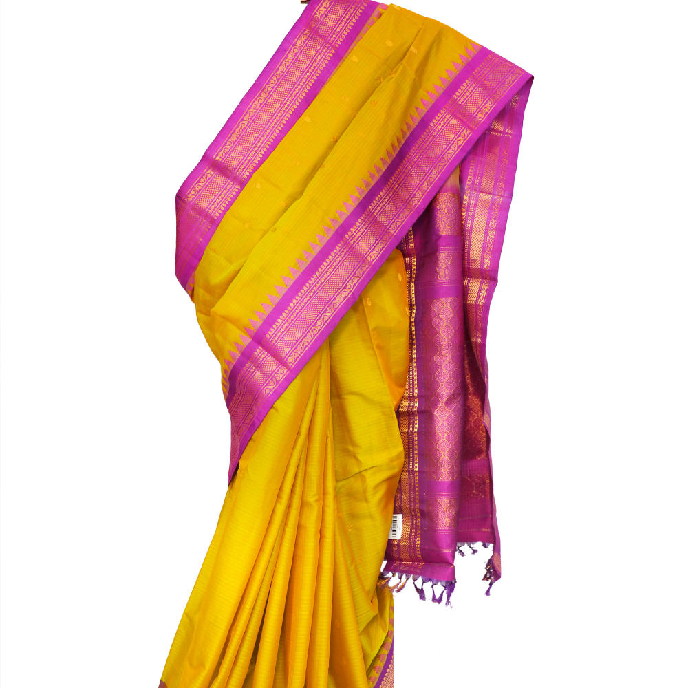 Handloom Gadwal silk cotton saree with all-over zari buttis and rich brocade pallu.
