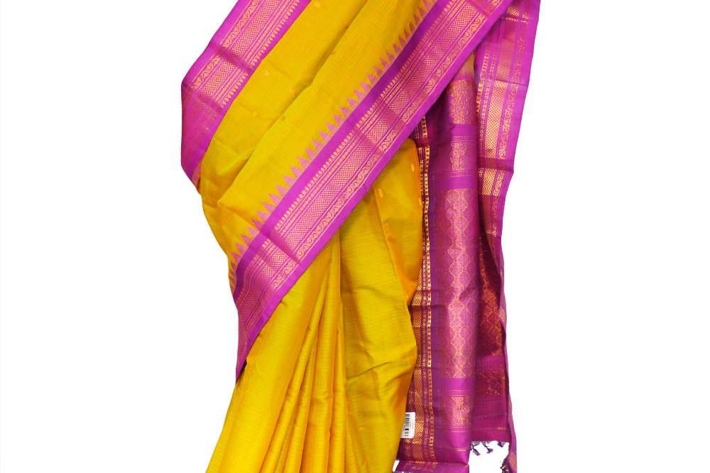 Handloom Gadwal silk cotton saree with all-over zari buttis and rich brocade pallu.
