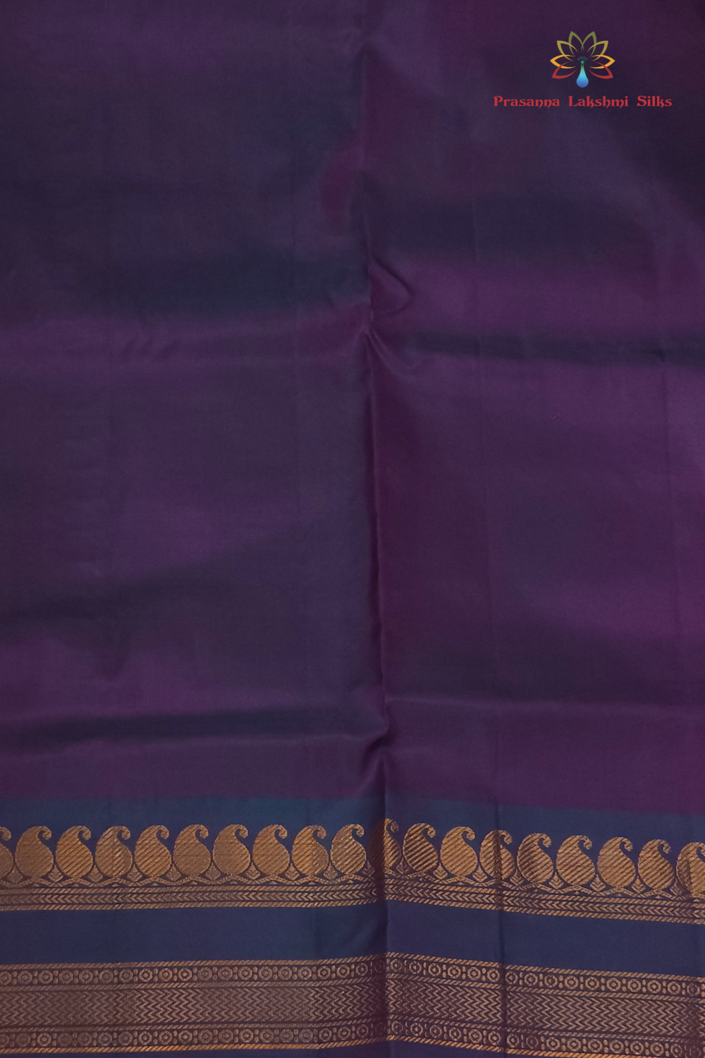 Purple saree with a decorative border featuring a brand logo in the corner.