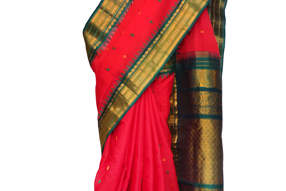 Handloom Gadwal silk cotton saree with all-over zari buttis and rich brocade pallu.
