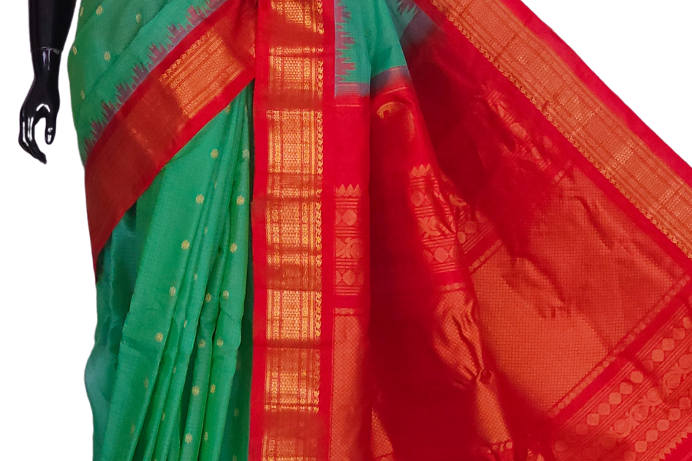 Handloom Gadwal silk cotton saree with all-over zari buttis and rich brocade pallu.

