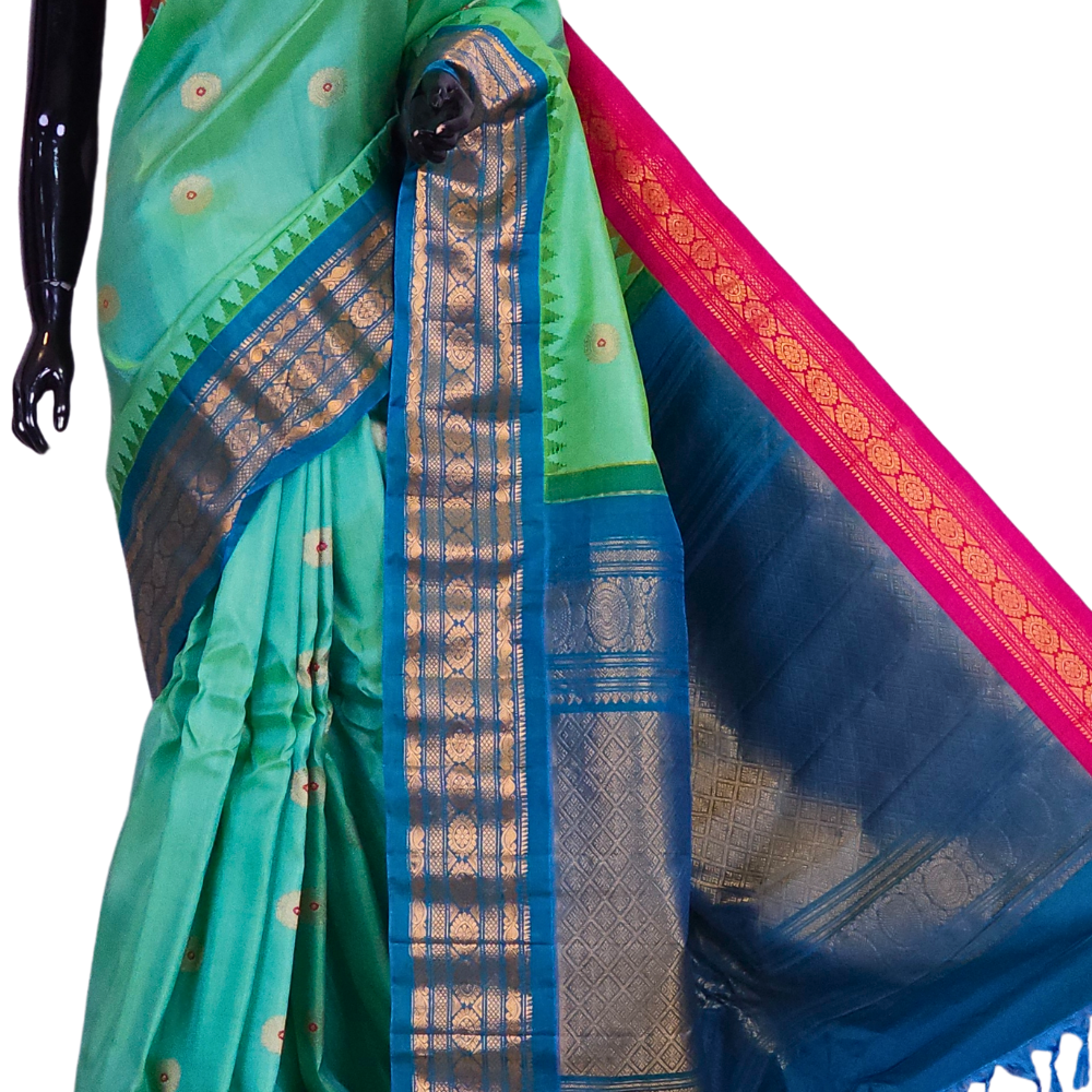 Sea green Gadwal silk saree featuring intricate zari motifs and a unique teal blue and pink Ganga Jamuna rich zari border, draped elegantly to showcase the full color contrast.