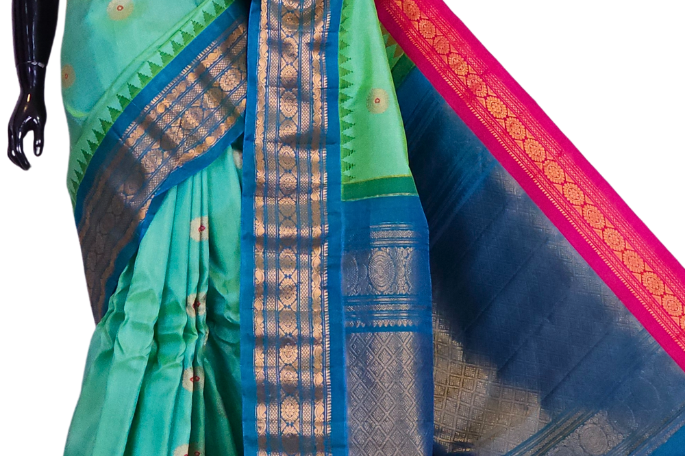 Sea green Gadwal silk saree featuring intricate zari motifs and a unique teal blue and pink Ganga Jamuna rich zari border, draped elegantly to showcase the full color contrast.