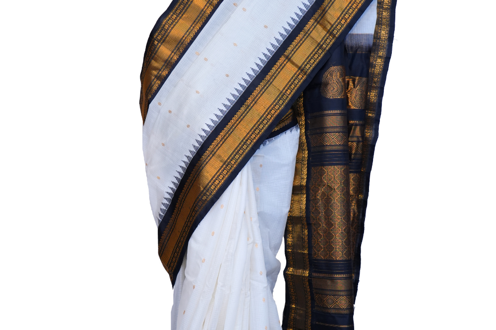 Handloom Gadwal silk cotton saree with all-over zari buttis and rich brocade pallu.
