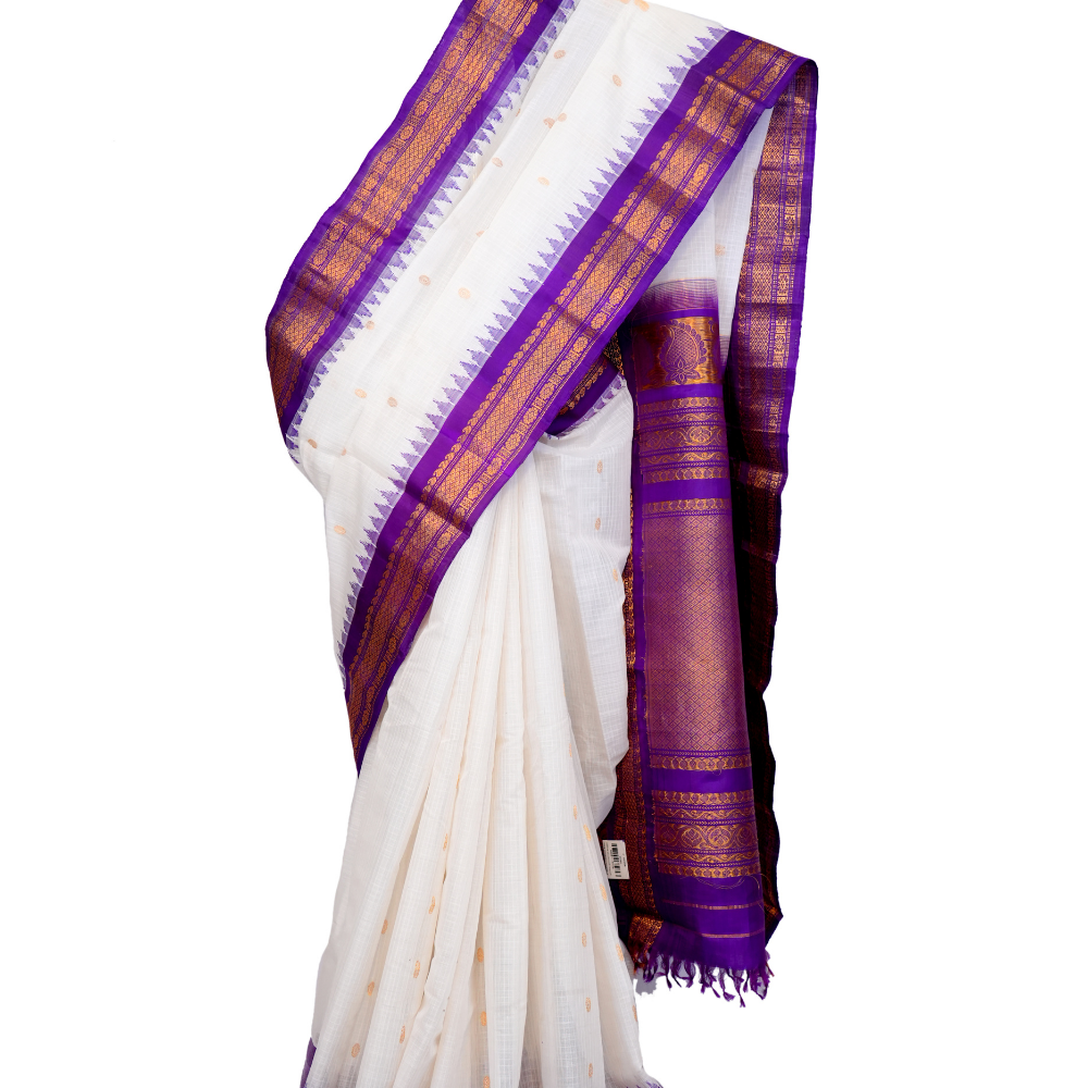 Handloom Gadwal silk cotton saree with all-over zari buttis and rich brocade pallu.
