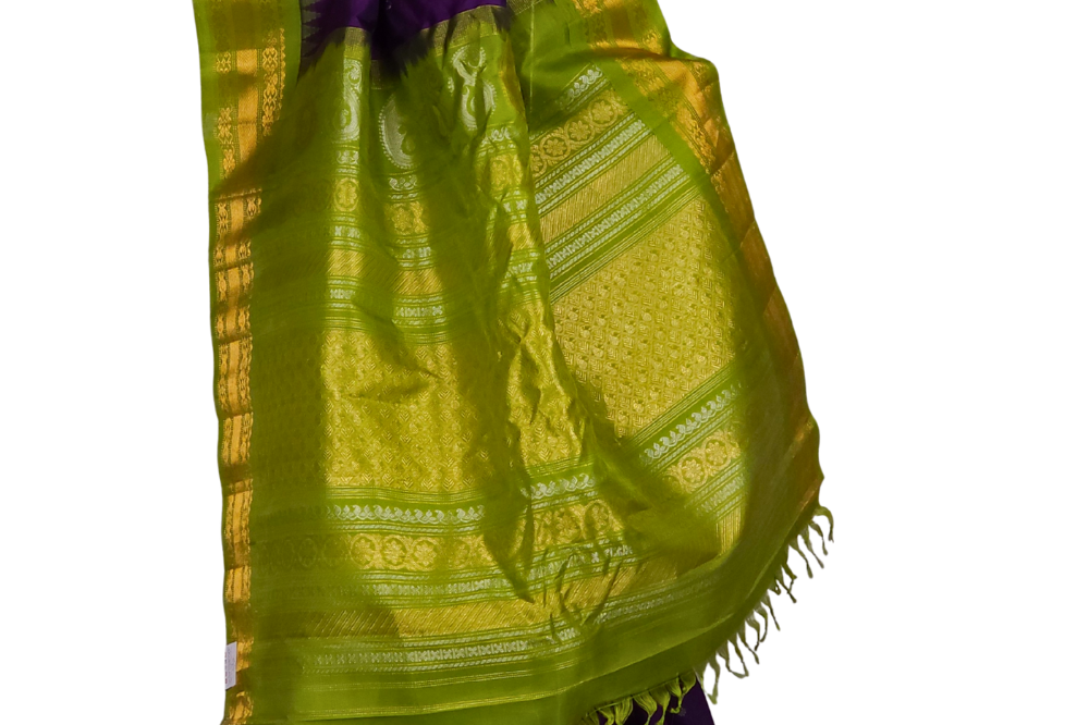 Close-up shot of the rich zari-woven brocade pallu on a handloom violet Gadwal pure silk saree, showcasing the detailed craftsmanship.